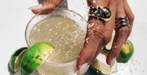 Main sur un verre de jus de citron